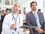 Join the 41st Annual Shoulder Course: Elevate Your Expertise in Shoulder Surgery A diverse group of professionals, including a female doctor and a businessman, attentively attending a seminar.