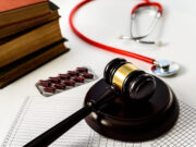 False Claims Act Settlement: Tacoma Orthopaedic Surgeon and Hospital Resolve Allegations of Medically Unnecessary Surgeries A gavel, a stethoscope, a stack of books, and a blister pack of capsules, symbolizing the intersection of law, medicine, and pharmaceuticals.