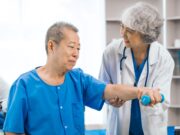 Geriatric Orthopaedics: Optimizing Care for Elderly Patients An elderly man is receiving physical therapy assistance from a female healthcare professional in a medical setting.