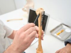 The Evolution of Implant Designs in Orthopaedics A healthcare professional explains the details of an orthopedic implant on a bone model.