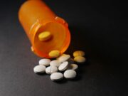 New Jersey Orthopaedic Surgeon Pleads Guilty to Illegally Prescribing Controlled Substances An orange prescription bottle lies on its side, spilling white tablets onto a dark surface.