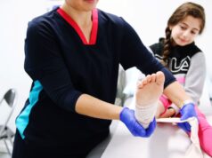 Advancements in Pediatric Orthopaedics: Managing Congenital and Developmental Disorders An orthopaedic nurse is applying a bandage to the ankle of a young girl in a clinical setting.