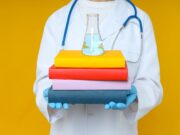 The Role of Continuing Medical Education in Orthopaedics A medical professional holds a stack of colorful books with a laboratory flask on top, symbolizing the intersection of medical education and scientific research.
