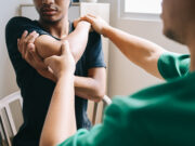 From Surgery to Recovery: Effective Physical Therapy Protocols in Orthopaedics A healthcare professional performs a physical examination on a patient's elbow in a clinical setting.