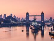 Innovate and Connect: Surgeons Congress 2024 Comes to London This image captures a serene view of London's Tower Bridge at dawn, with the city skyline and a moored ship reflecting on the calm waters of the Thames.