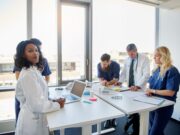 Spine-Tingling Strategies: Navigating Orthopaedic Business Models with Precision A diverse group of healthcare professionals is having a collaborative meeting in a bright, modern clinic setting.