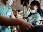 Global Surgical Missions and the Lessons Orthopaedic Surgeons Bring Home group of volunteers with working in community charity event