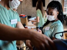 Global Surgical Missions and the Lessons Orthopaedic Surgeons Bring Home group of volunteers with working in community charity event