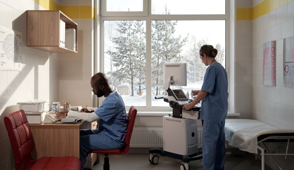 Cold Weather Joint Stiffness and Its Impact on Surgical Timing Doctors in hospital room with snow outside the window